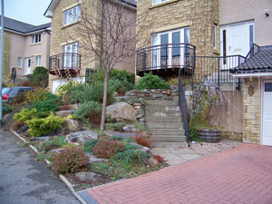 Steap ground can always be difficult to deal with..so install a nice rockery..